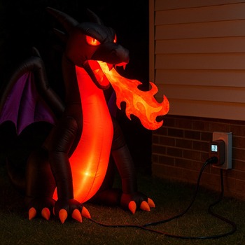 Halloween Inflatable Dragon breathing fire at night with power cord plugged in