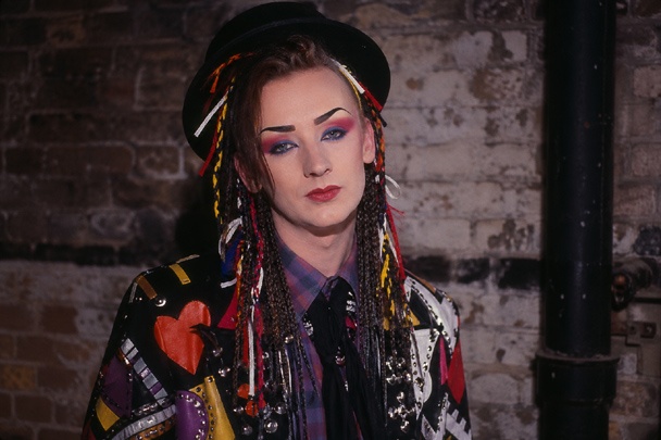 DIY Boy George Costume with braided bowler hat, graphic brows, blended red and blue eye shadow, red lips, bold jacket
