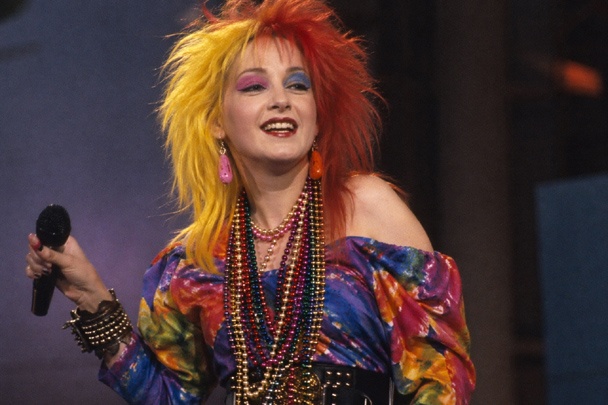 DIY Cyndi Lauper Costume with multicolor dress, Mardi Gras beads, two tone teased hair, mismatched earrings, and pink and blue mismatched eye shadow