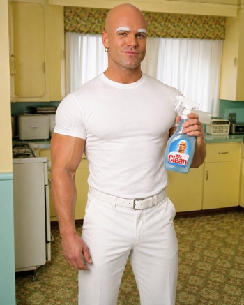 DIY Mr. Clean Costume with white t-shirt over muscle suit, white pants, bald cap, white eyebrows, and gold hoop earring