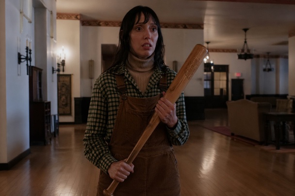 DIY Wendy Torrance Costume with corduroy overall dress, flannel shirt, ribbed sweater, knee high boots, and wooden baseball bat
