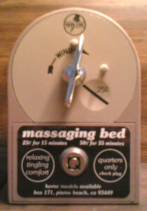 Magic Fingers vibrating bed control mounted beside a bed in a mid-century motel room