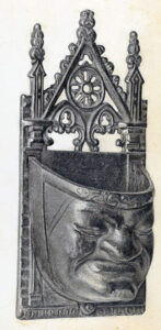Antique cast iron wall-mounted match safe with a sculpted face design displayed as an example of <strong data-Collecting Match Safes.