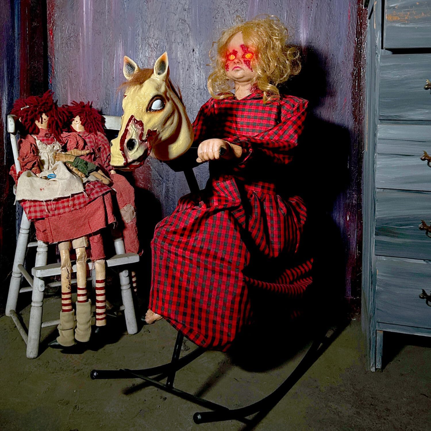 Rocking Horse Girl Animatronic in darkened Halloween room display with glowing eyes active