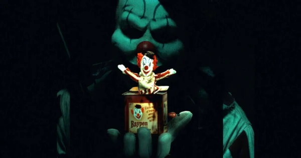 Clown in a Cornfield Review featuring a sinister clown hiding among the corn stalks beneath a full moon