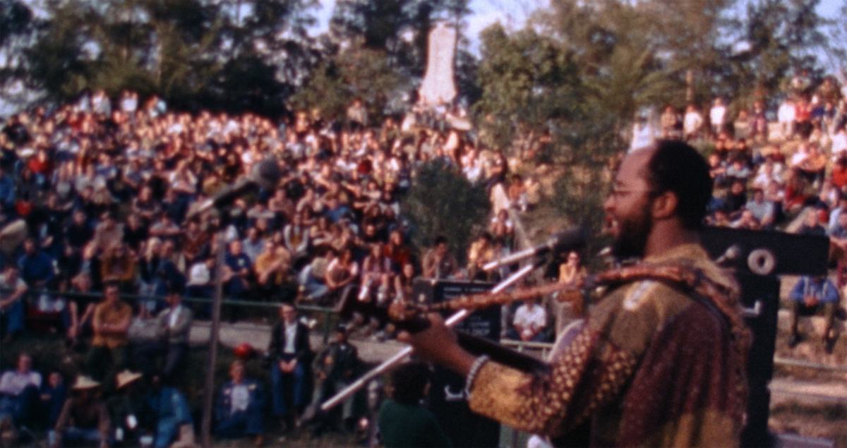 Guitarist performing before a crowd during the anti-war entertainment tour featured in the F.T.A. Review.