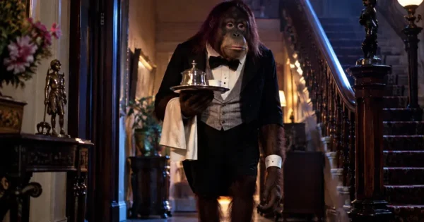 Link Review featuring the sinister orangutan dressed as a butler inside a shadowy English country mansion in the 1986 horror thriller.