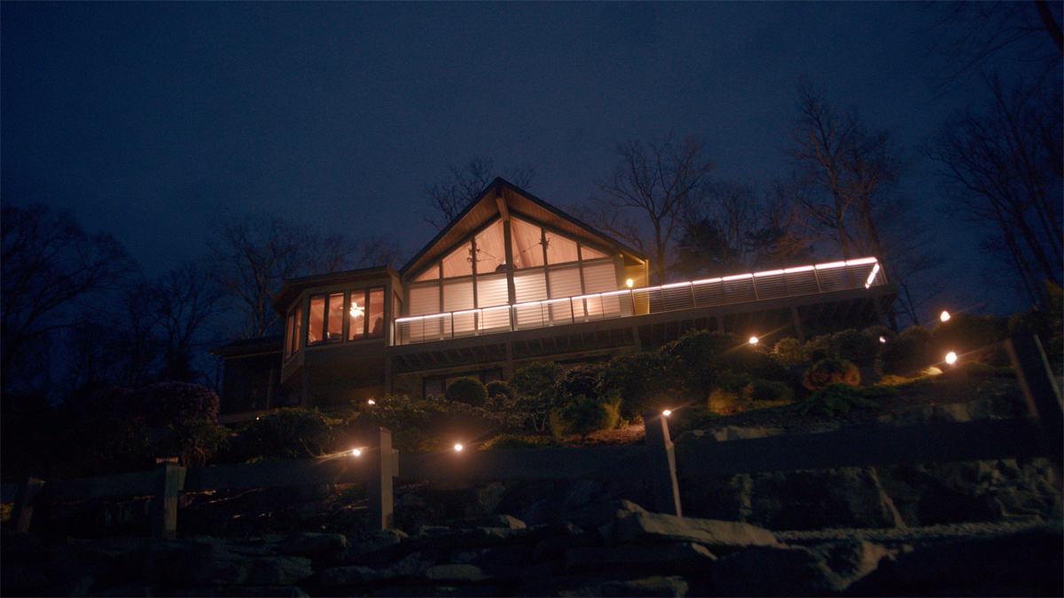 Malicious 2023 Review showing the isolated house surrounded by woods where the horror thriller unfolds.